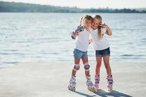 Posing for a camera. Happy female friends on roller skates. Leisure time photo