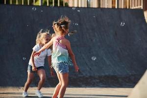 Having fun with bubbles. Leisure activities. Two little girls having fun in the park photo