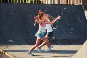 Having fun with bubbles. Leisure activities. Two little girls having fun in the park photo