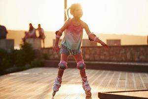 Happy cute kid riding on her roller skates. Unbelievable sunlight photo