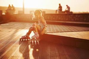 Happy cute kid with her roller skates. Unbelievable sunlight photo