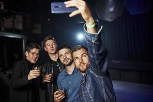 People have fun in the night club. With alcohol in hands photo