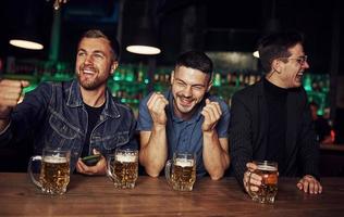 divirtiéndose. amigos descansando en el pub con alcohol en las manos foto