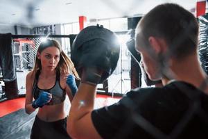 Behind the fence. Athletic young people have sparring on the boxing ring photo