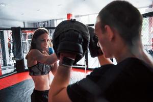 Behind the fence. Athletic young people have sparring on the boxing ring photo