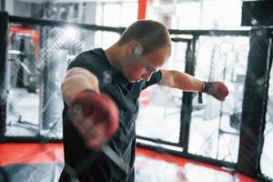 Taking a break. Sportsman at boxing ring have exercise. Leaning on the fence photo