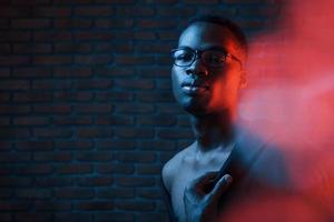 la luz parpadea. neón futurista. joven afroamericano en el estudio foto