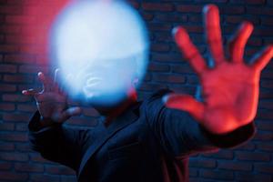Light blinks. Futuristic neon. Young african american man in the studio photo