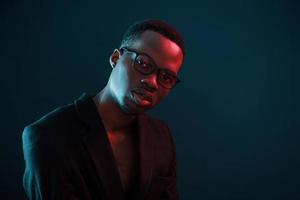 Fashion model. Futuristic neon lighting. Young african american man in the studio photo