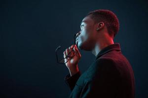 Fashion model. Futuristic neon lighting. Young african american man in the studio photo