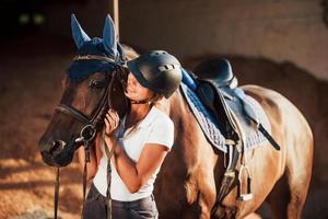 Ready for the ride. Horsewoman in uniform and black protective helmet with her horse photo