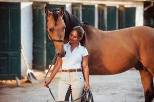 Getting ready for the ride. Horsewoman in white uniform with her horse at farm. Ready for the ride photo