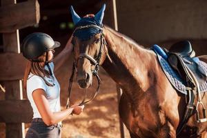 Animal is in blue clothes. Horsewoman in uniform and black protective helmet with her horse photo