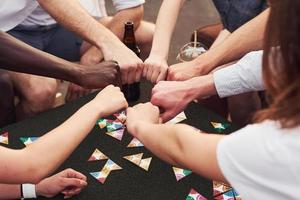 unidad de la gente. un grupo de jóvenes con ropa informal tienen una fiesta en la azotea juntos durante el día foto