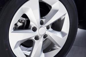 Close up view of automobile's wheel. Brand new car parked indoors photo