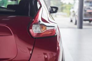 Rear particle view of brand new red car that parked indoors photo