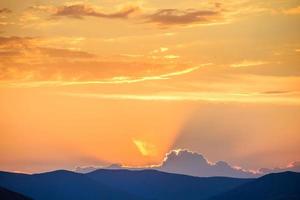 Dramatic sky over mountain silhouette photo