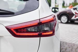 Rear particle view of modern white automobile. Close up view of headlights photo