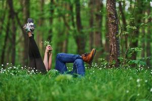 Couple lying down on the grass in forest together at daytime photo