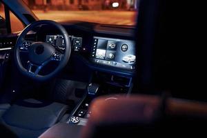 Steering wheel and navigation display. Close up view of front park of new modern black automobile photo