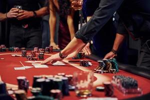 People in elegant clothes standing and playing poker in casino together photo