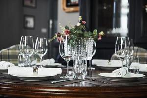 Natural daylight. Picture of served table with glasses, plant and silver colored fork and knife photo