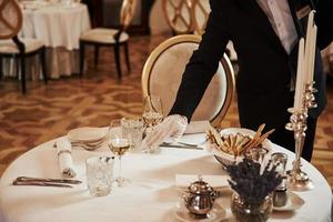 Professional waiter preparing the table in the vintage style luxure restaurant photo