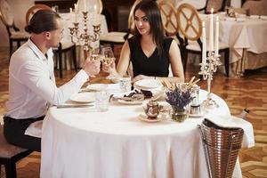 esperando la comida. una pareja hermosa tiene una cena romántica en un restaurante de lujo por la noche foto