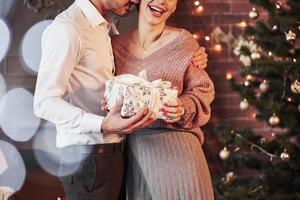 Finally holiday present. Nice couple celebrating new year in the new year decorated room photo