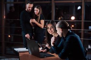 I understand what you tying to say. Team of young business people works on their project at night time in the office photo