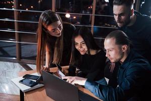 No breaks, keep working. Team of young business people have meeting at night time in the office photo