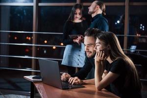 When others sleep they do job. Team of young business people works on their project at night time in the office photo