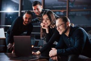 Energy of happy friends. Team of young business people works on their project at night time in the office photo