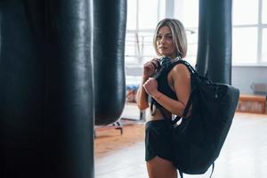 It will be nice day. Adult female with black bag and headphones in the training gym photo