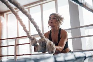 Some big competitions is coming, need to be ready. Blonde sport woman have exercise with ropes in the gym. Strong female photo