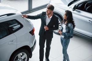 Ordinary working day. Female customer and modern stylish bearded businessman in the automobile saloon photo