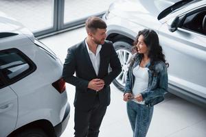 Need some advices. Female customer and modern stylish bearded businessman in the automobile saloon photo