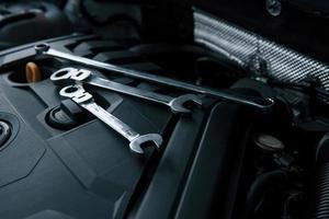 Three wrenches. Repair tools lying down on the engine of automobile under the hood photo