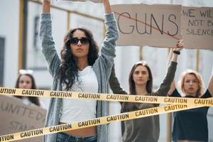 Word guns is crossed out. Group of feminist women have protest for their rights outdoors