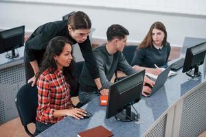 Advice needed from you. Group of young people in casual clothes working in the modern office photo