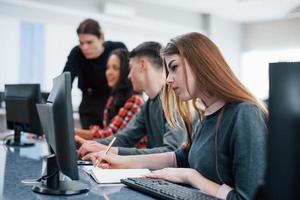 Some results of work. Group of young people in casual clothes working in the modern office photo