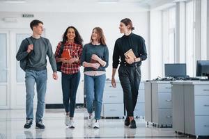 Getting prepared for today's work. Group of young people walking in the office at their break time photo