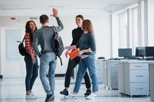 Finally we met. Group of young people walking in the office at their break time photo