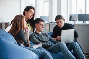 Hard to find information that we need. Group of young people in casual clothes working in the modern office photo