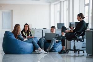 condiciones confortables. grupo de jóvenes con ropa informal trabajando en la oficina moderna foto