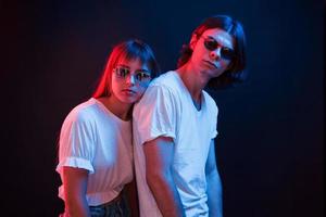 Couple standing in dark room with red and blue neon lighting photo