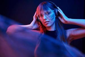 Like woman from some kind of videogame. Studio shot in dark studio with neon light. Portrait of young girl photo