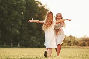 Giving hugs. Mother and daughter enjoying weekend together by walking outdoors in the field. Beautiful nature photo