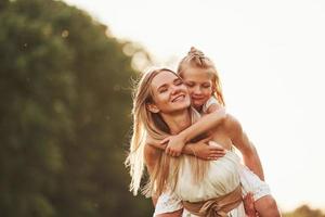 I hold you, don't worry. Mother and daughter enjoying weekend together by walking outdoors in the field. Beautiful nature photo