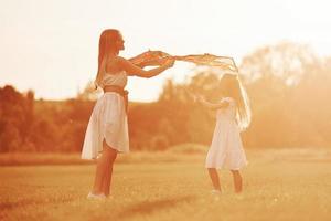 It will fly. Mother and daughter have fun with kite in the field. Beautiful nature photo